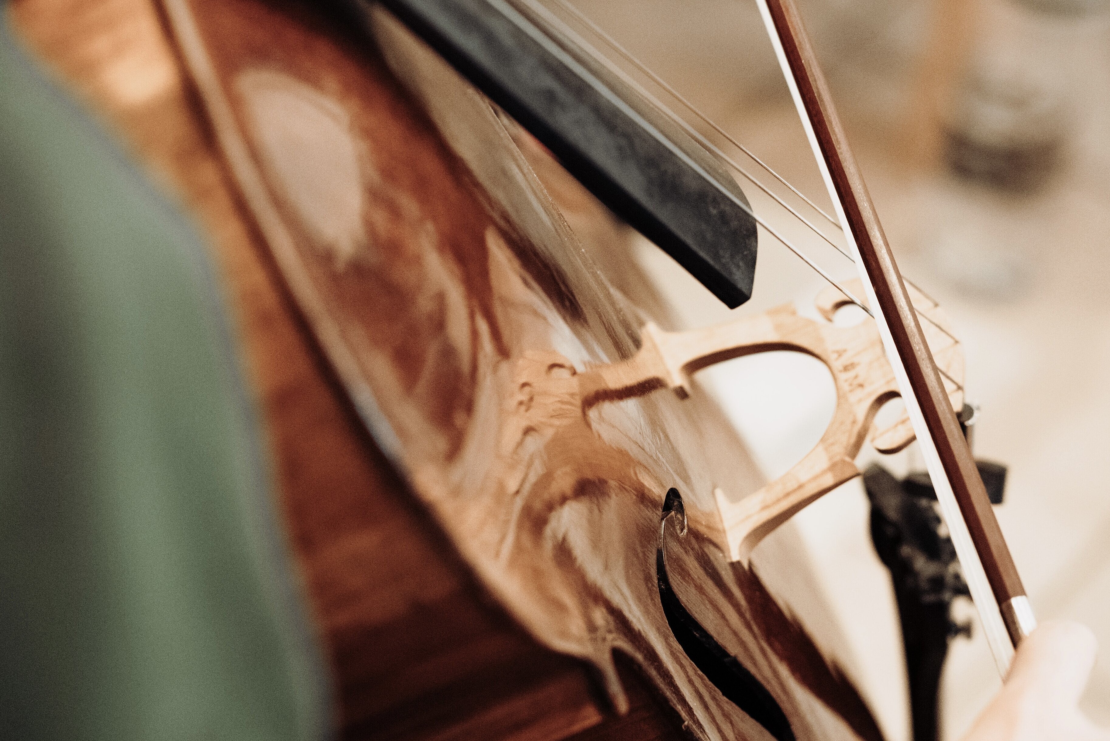 Nahaufnahme eines gespielten Cellos mit Bogen, Foto: Max Börner
