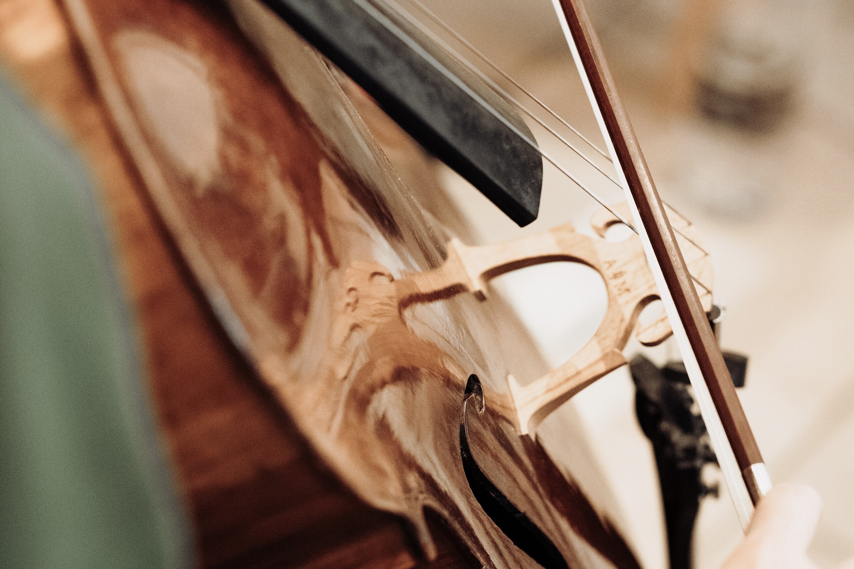 Nahaufnahme eines gespielten Cellos mit Bogen, Foto: Max Börner